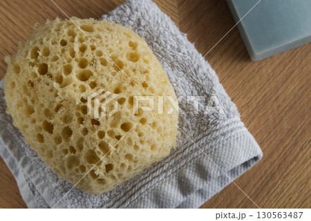 Dermo Aqua soft bath sponge on a wooden background 130563487