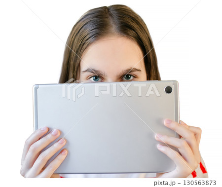 Teen girl wearing striped shirt smiles as she watches something on her tablet while seated in train Teen girl wearing striped shirt smiles as she watches something on her tablet while seated in train 130563873
