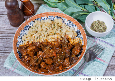 Delicious hungarian goulash with spaetzle on rustic wooden table 130563899