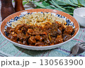Delicious hungarian goulash with spaetzle, a traditional stew, resting on rustic table 130563900