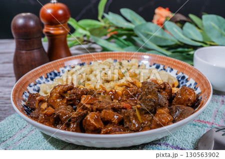 Delicious hungarian goulash with spaetzle on a decorated plate 130563902