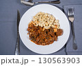 Delicious hungarian goulash with spaetzle on white plate 130563903