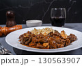 Delicious hungarian goulash with spaetzle accompanying red wine 130563907