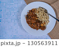 Delicious plate of goulash with spaetzle, a traditional hungarian dish, resting on a table 130563911
