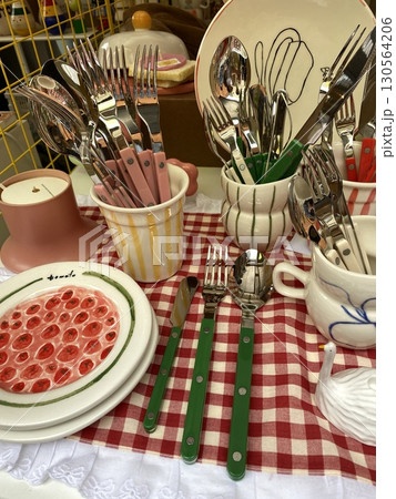 Assorted cutlery and crockery arranged on checkered table for kitchenware and dining concept 130564206