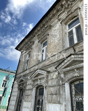 Ornate historic building facade against blue sky with clouds, suitable for architectural background Ornate historic building facade against blue sky with clouds, suitable for architectural background 130564213