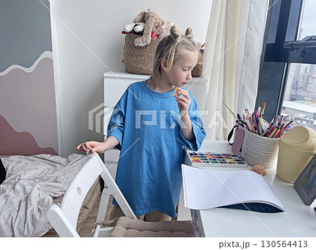 Curious little child girl with opened empty sketchbook on table. Domestic life, leisure activity Curious little child girl with opened empty sketchbook on table. Domestic life, leisure activity 130564413