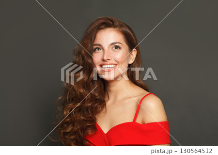 Lovely woman with long hair and make-up on black background. Gorgeous woman with curly hairstyle Lovely woman with long hair and make-up on black background. Gorgeous woman with curly hairstyle 130564512