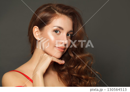 Closeup portrait of woman with long hair and make-up on black background. Gorgeous woman Closeup portrait of woman with long hair and make-up on black background. Gorgeous woman 130564513