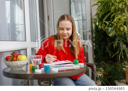Adorable child painting with bright colors. Young girl at home, hobby and leisure Adorable child painting with bright colors. Young girl at home, hobby and leisure 130564865