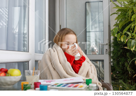 Cute young child relaxing and drinking tea or coffee after painting Cute young child relaxing and drinking tea or coffee after painting 130564877