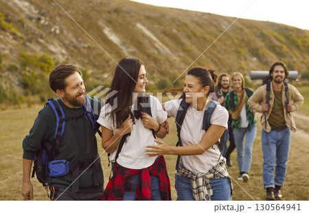 Group of friends having fun, talking and laughing during a walking tour of the mountains. 130564941