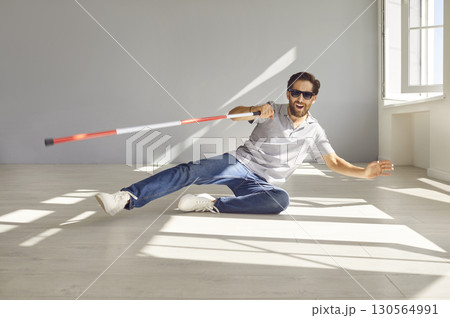 Blind Man with Glasses and Cane Falling to the Ground 130564991