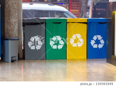 A set of colorful recycling bins indoors. Sustainability, environmental awareness, and urban waste management. A set of colorful recycling bins indoors. Sustainability, environmental awareness, and urban waste management. 130565849