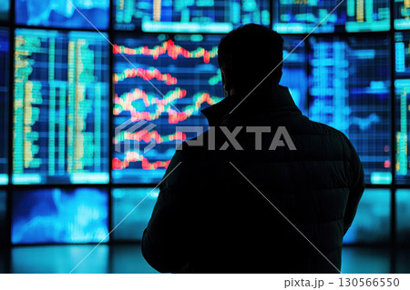 Consultant analyzing market data on digital screens, showcasing financial services 130566550