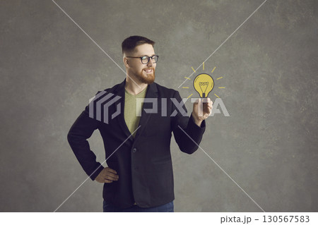 Man holds a painted yellow light bulb in his hand, which symbolizes a wonderful idea. Man holds a painted yellow light bulb in his hand, which symbolizes a wonderful idea. 130567583