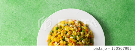 Colorful salad includes boiled egg, chicken breast, diced potatoes, carrots, and green peas mixed together and drizzled with olive oil, perfect for a healthy meal, banner 130567993