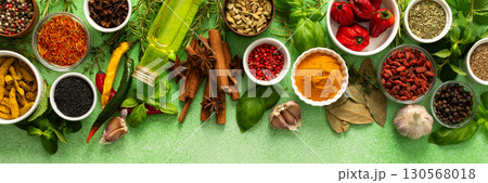 A beautiful collection of colorful spices and herbs, showcasing their natural aromas and vibrant hues on a gentle green background, top view , banner A beautiful collection of colorful spices and herbs, showcasing their natural aromas and vibrant hues on a gentle green background, top view , banner 130568018