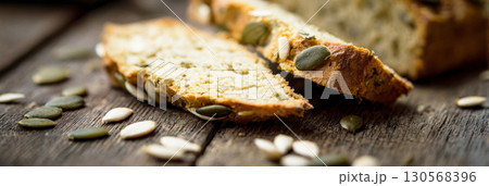 Homemade bread enriched with pumpkin seeds, ideal for autumn gatherings. The warm, flavorful loaf invites cozy moments and delicious meals during the fall season, banner 130568396