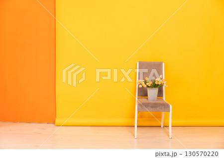 chair in the interior of an empty yellow orange room chair in the interior of an empty yellow orange room 130570220