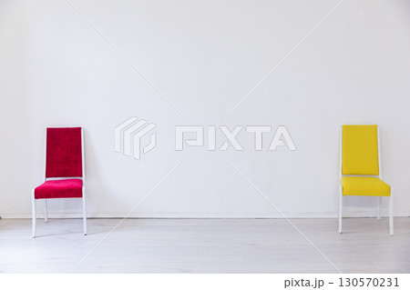 Red and yellow chair in the interior of an white room 130570231