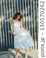 woman smiling in light summer dress outdoors 130570262