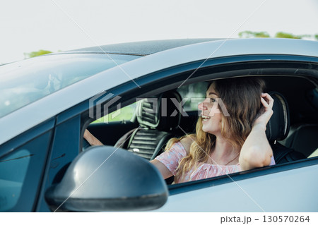 Excited young woman driving vehicle confidently, Excited young woman driving vehicle confidently, 130570264
