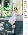 woman smiling in light summer dress outdoors 130570265