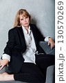 Portrait of a beautiful young woman in a black suit 130570269