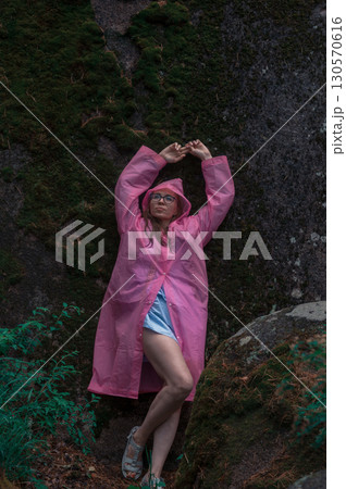 Woman in the taiga forest and rocks of the Stolby nature reserve park 130570616