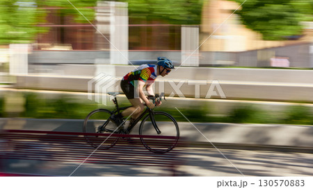 Cyclist speeding on road bike in motion blur with strong focus and determined emotion 130570883