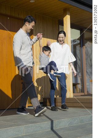 家の前に立つ家族 　 130571002