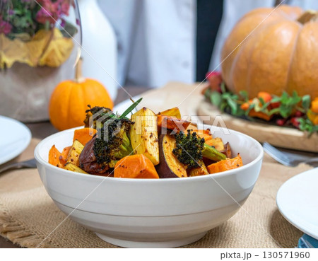 Bowl of Roasted Vegetables and Pumpkins on a Thanksgiving Table Setting 130571960