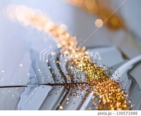 Golden Glitter Cascade on Textured Gray Surface with Bokeh in Bright Abstract Lighting 130571998