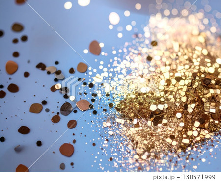 Golden Glitter Pile on Light Blue Surface Macro Shot with Bokeh Effects Close Up 130571999