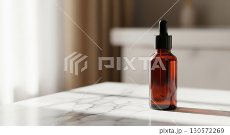 Amber Glass Bottle with Dropper on Marble Tabletop in Soft Window Light 130572269