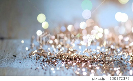 Abstract Bronze Glitter Scattered on Light Wood Surface with Bokeh Background 130572375