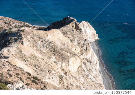 Limestone white cliffs of Cape Aspro plunging into deep blue Mediterranean waters near Pissouri, Cyprus, revealing dramatic coastal scenery 130572544
