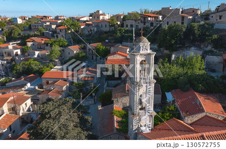 Aerial view capturing the picturesque Lofou village with traditional stone houses and a prominent white church bell tower. Limassol District, Cyprus Aerial view capturing the picturesque Lofou village with traditional stone houses and a prominent white church bell tower. Limassol District, Cyprus 130572755