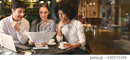 Millennial business team discussing project in cafe, reading contract terms and conditions during business lunch, free space 130573106