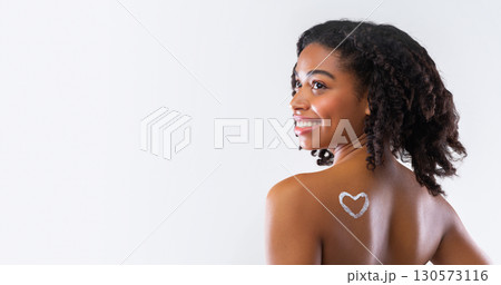 Beauty Skin Care. Cream In Heart Shape On Black Girl Shoulder, Grey Studio Background, panorama with copy space Beauty Skin Care. Cream In Heart Shape On Black Girl Shoulder, Grey Studio Background, panorama with copy space 130573116