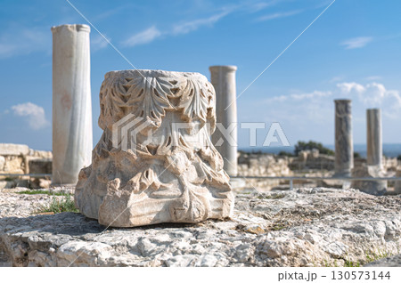 Corinthian capital with intricate acanthus leaf carving resting among ancient column fragments at Kourion archaeological site, Cyprus 130573144