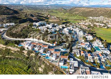 Aerial view of Pissouri village, with white houses, swimming pools, green hills, and agricultural fields, in Limassol district, Cyprus Aerial view of Pissouri village, with white houses, swimming pools, green hills, and agricultural fields, in Limassol district, Cyprus 130573148