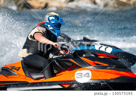 Dynamic shot of a racer on a jet ski navigating turbulent river waters with intense focus 130573193