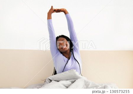 Good Morning. Rested African American Girl Stretching Raised Arms Waking Up Sitting In Comfortable Bed In Cozy Bedroom. Empty Space Good Morning. Rested African American Girl Stretching Raised Arms Waking Up Sitting In Comfortable Bed In Cozy Bedroom. Empty Space 130573255