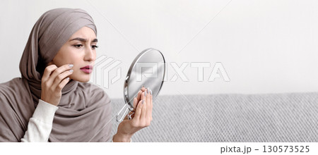 Problem Skin Concept. Muslim Girl In Hijab Looking In Round Mirror And Touching Face, Concerned About Wrinkle Or Pimple, Closeup Problem Skin Concept. Muslim Girl In Hijab Looking In Round Mirror And Touching Face, Concerned About Wrinkle Or Pimple, Closeup 130573525
