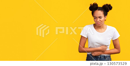 Period Pain. Sad black girl holding hands on stomach suffering from abdominal pain. Panorama, copy space 130573529