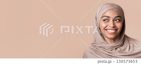 Portrait of beautiful black girl in hijab looking aside at copy space over yellow background, closeup Portrait of beautiful black girl in hijab looking aside at copy space over yellow background, closeup 130573653