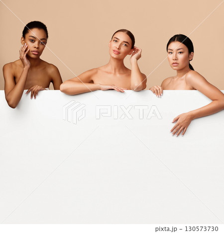 Three Diverse Women Models Posing Behind White Board For Text On Gray Studio Background. Beauty Banner With Copy Space 130573730