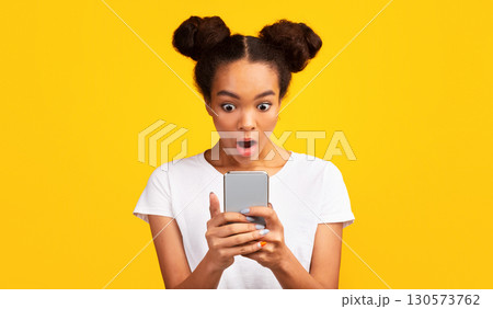 Human Reaction. Shocked african girl looking at phone seeing bad message. Panorama, free space 130573762